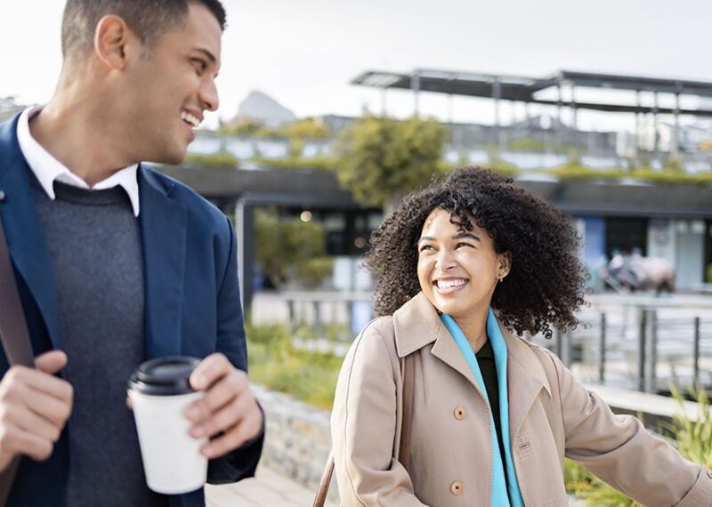 happy business people walking in urban city. Young woman and male co-worker cycling with eco friendly, sustainable journey.