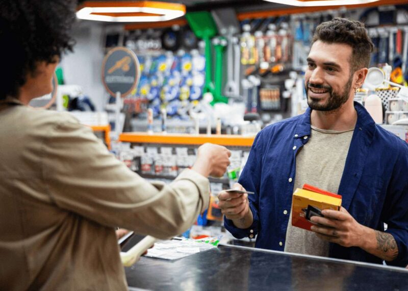 Man in retail store paying for items at register