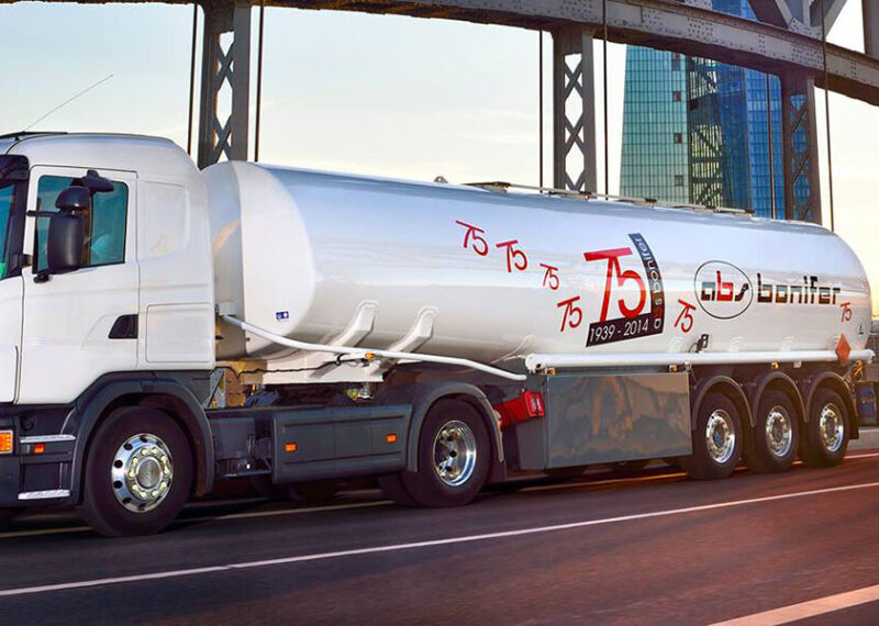white truck with abs logo driving on highway