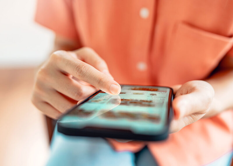 Woman browsing online store on mobile device with wide variety of products available.