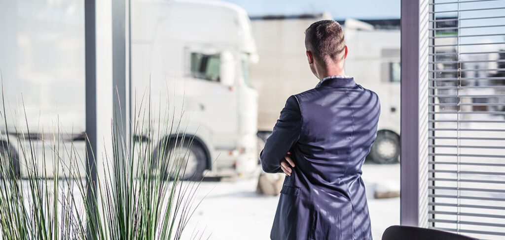 Male manager overseeing logistics for a fleet of trucks.