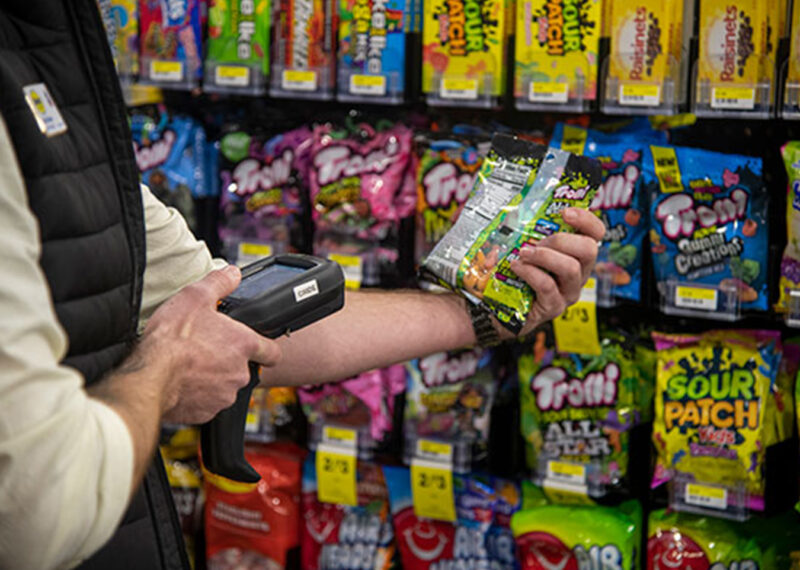 Grocery store employee scanning CPG products at retail store