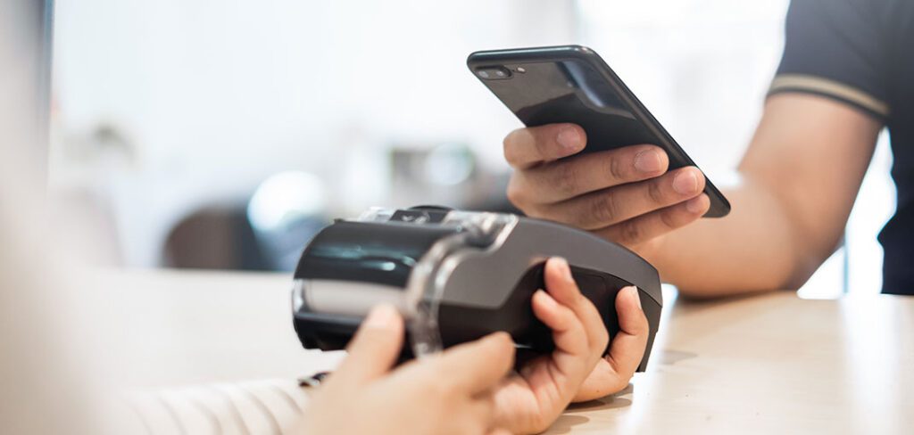 Customer using phone for payment to at cafe restaurant