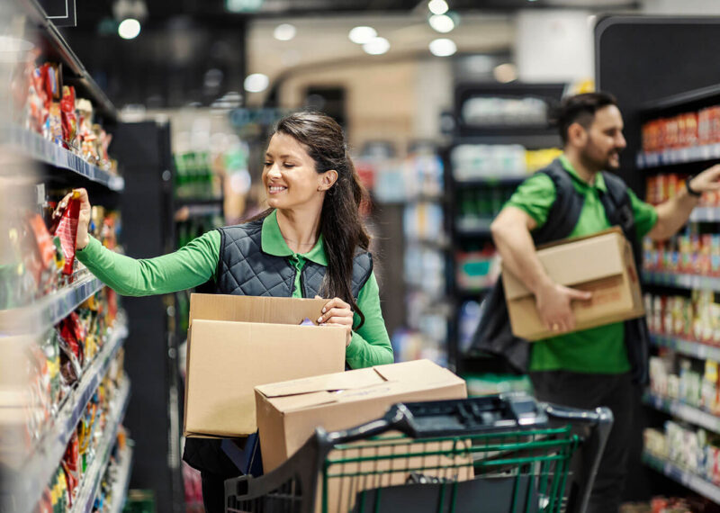 Woman and man stocking shelves in a grocery store
