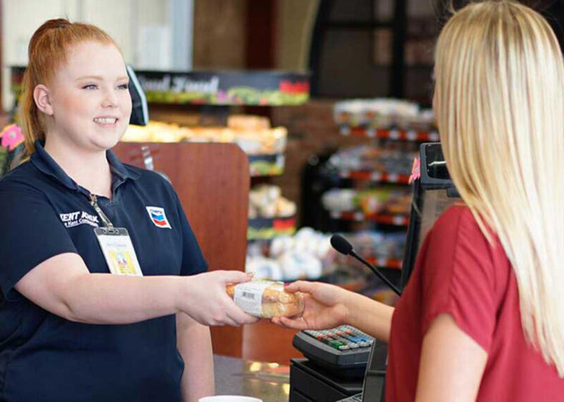 C-store seller giving food item to customer