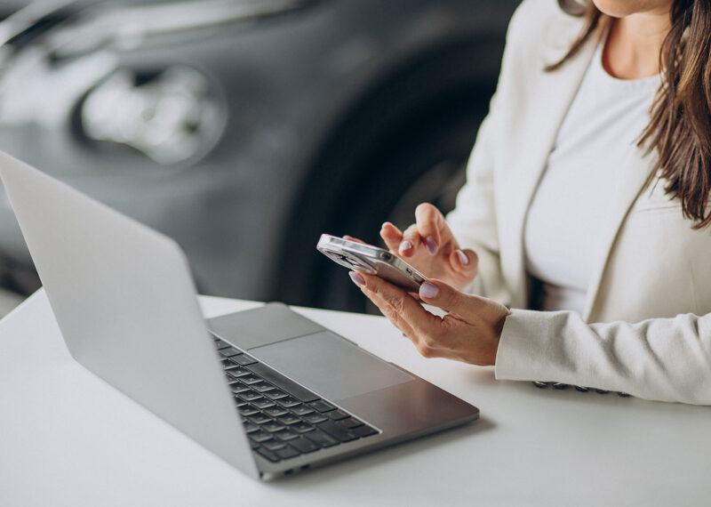 Business woman working on a laptop at the office of car showroom