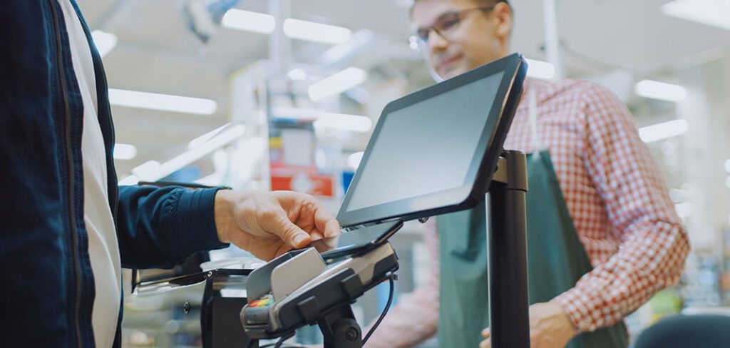 Checkout Counter Customer Pays with Smartphone for His Food Items