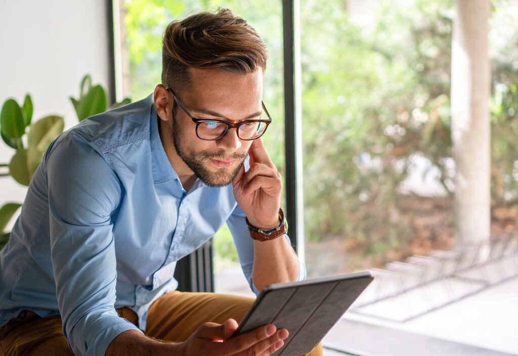 Young amiling Man looking at digital tablet