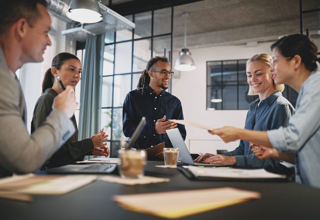 Young businessman talking with staff during an office meeting.