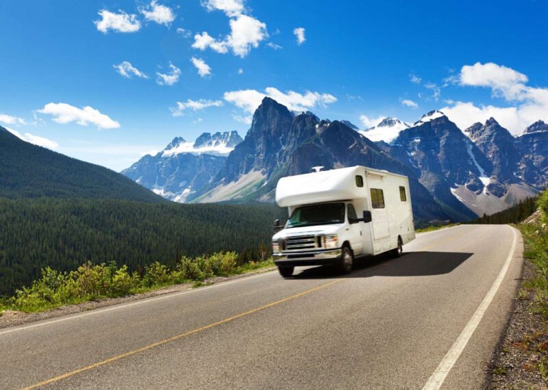 Camper truck driving on highway in the mountains on Labor Day