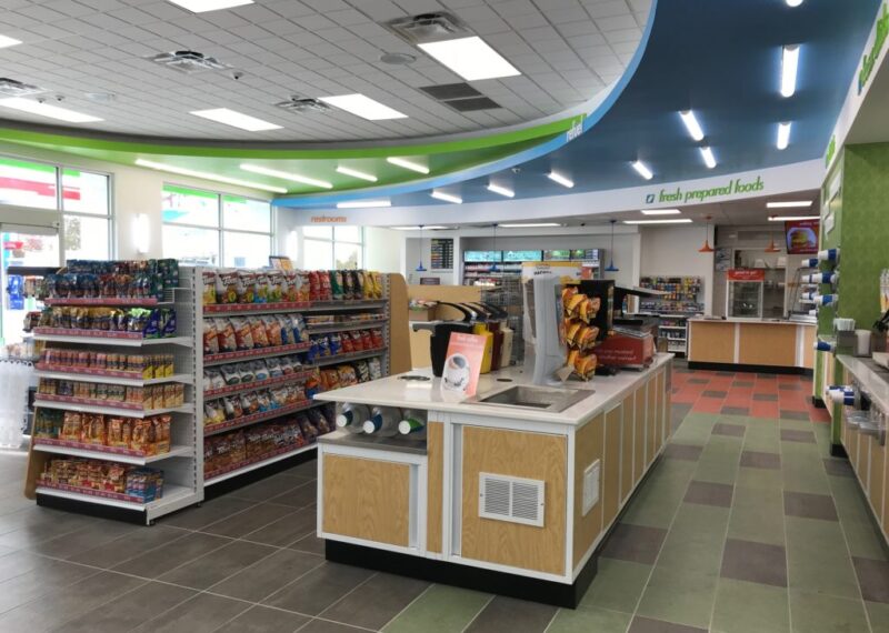 green and blue interior of convenience store with food aisles