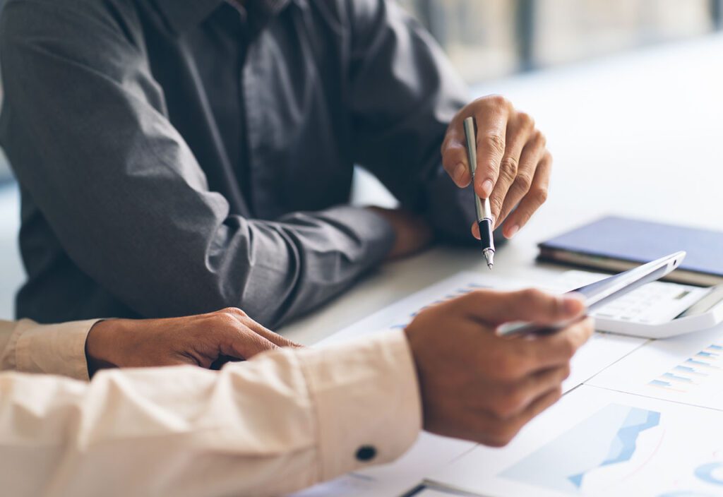 Close up of employees hands during collaborative data analysis session.