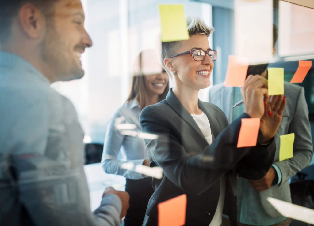 Group of people writing on sticky notes
