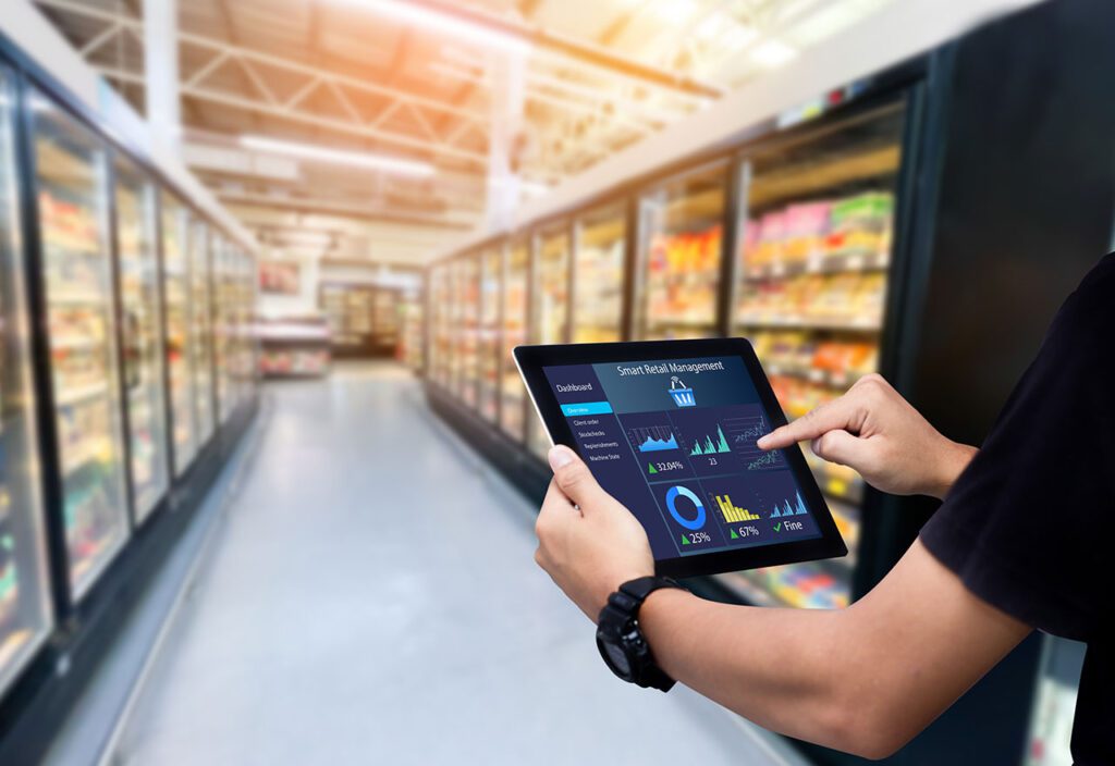 Employee using smart retail management software on tablet in consumer packaged goods store.