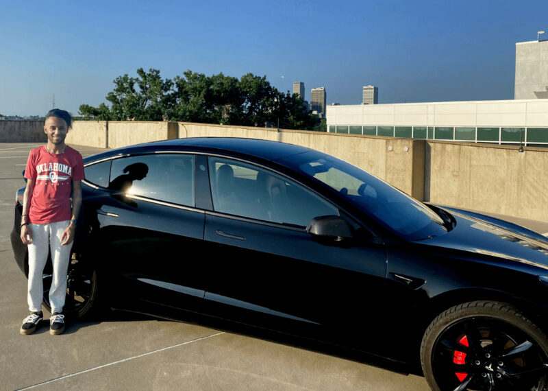 Keith Clark standing in front of his Tesla