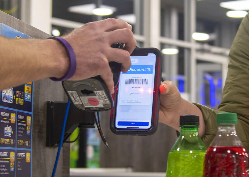 Man scanning loyalty discount on woman's mobile phone