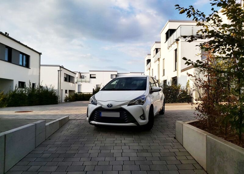 White hybrid Toyota car auto parked in apartment courtyard