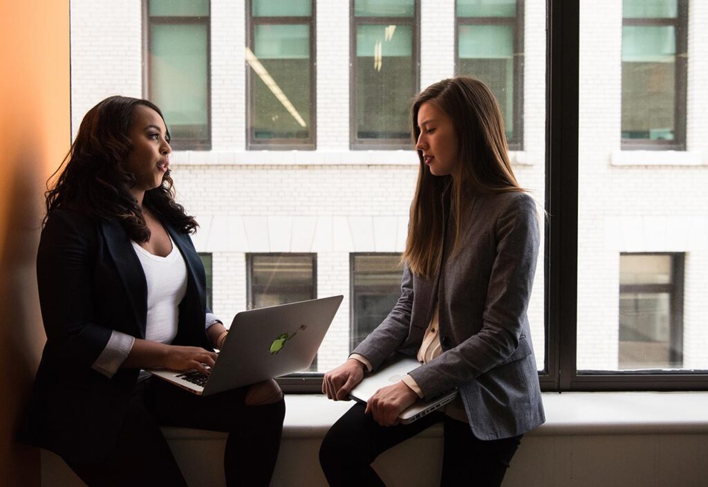 Young businessman talking on phone and using a laptop during a late night at work. 