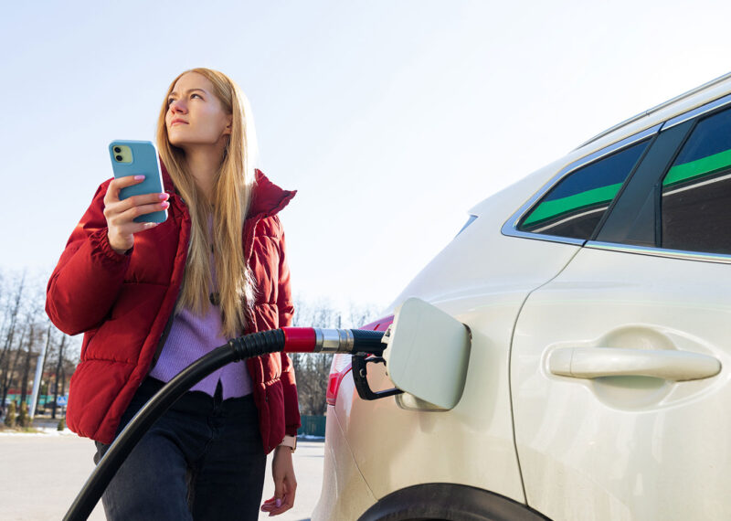 A young woman pays for gas at a convenience store using an app on her phone