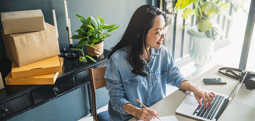 Woman sitting at desk working on office computer.