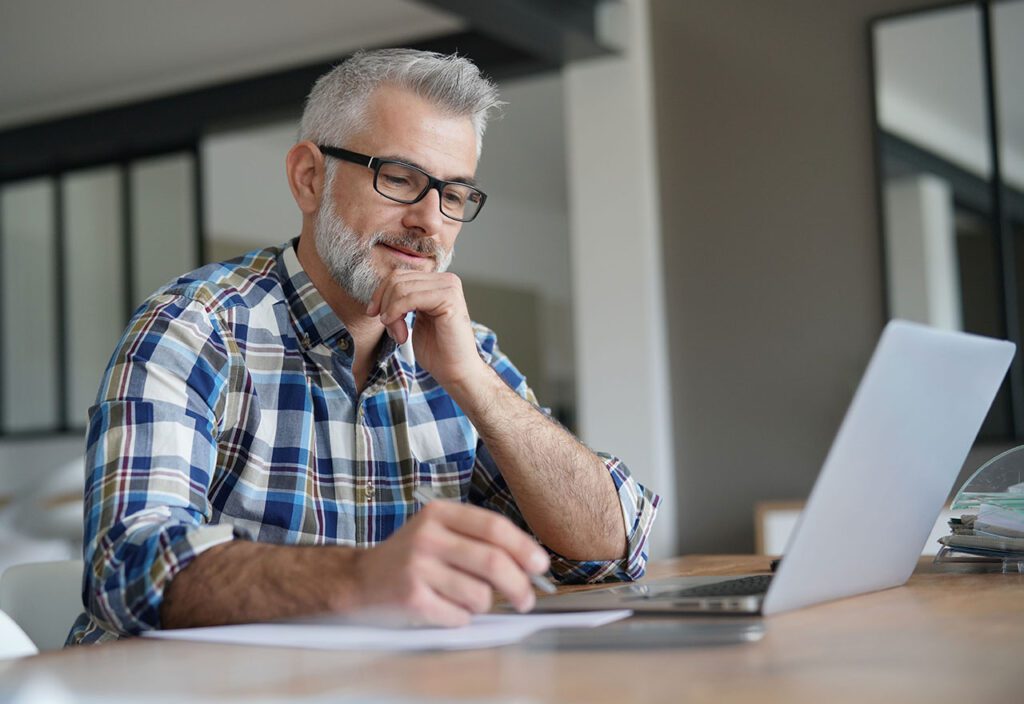 Older man working from home on his laptop.