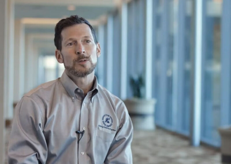 Photo of Bill Schierl sitting in lobby of hotel talking about PDI