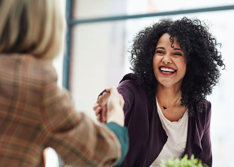 Handshake with a happy, confident and excited human resources manager and a female job candidate.