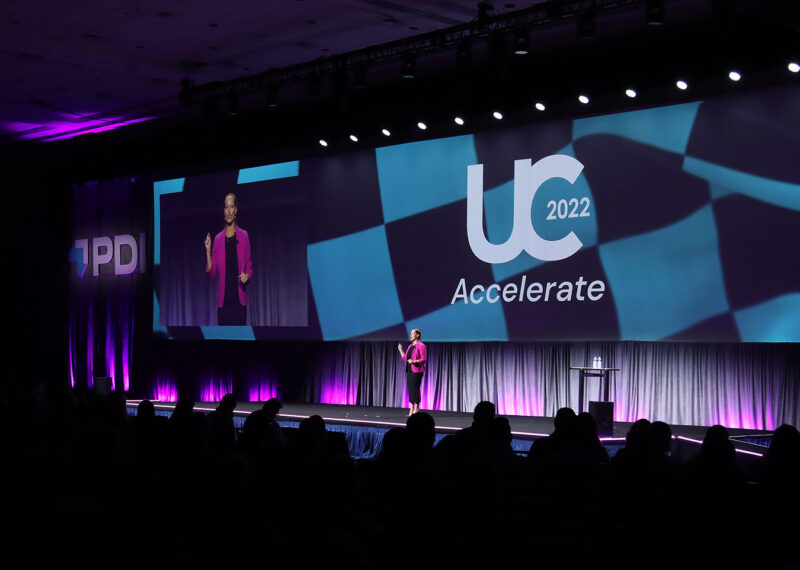 PDI COO Linnea Geiss standing on stage at UC 2022