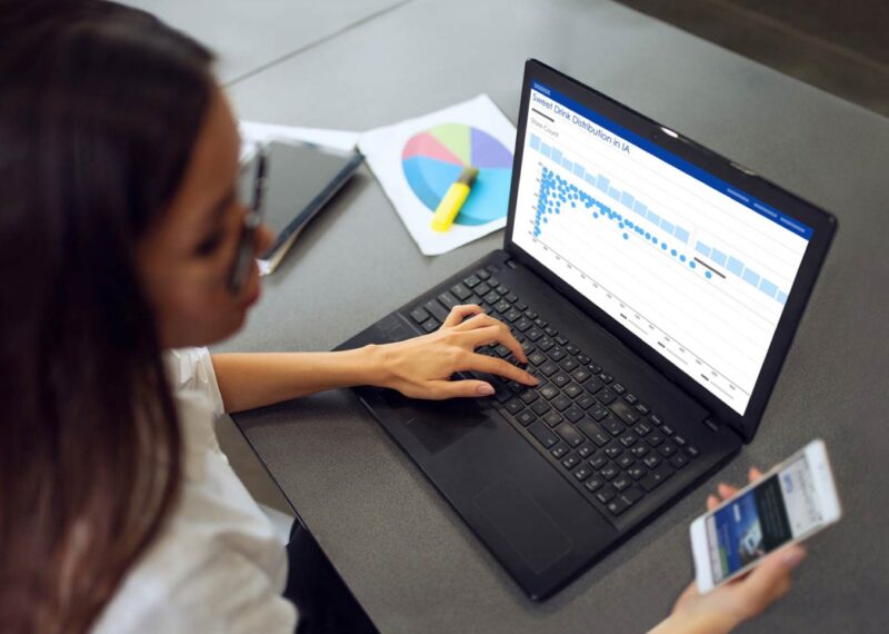 Woman using her mobile phone and laptop at the same time
