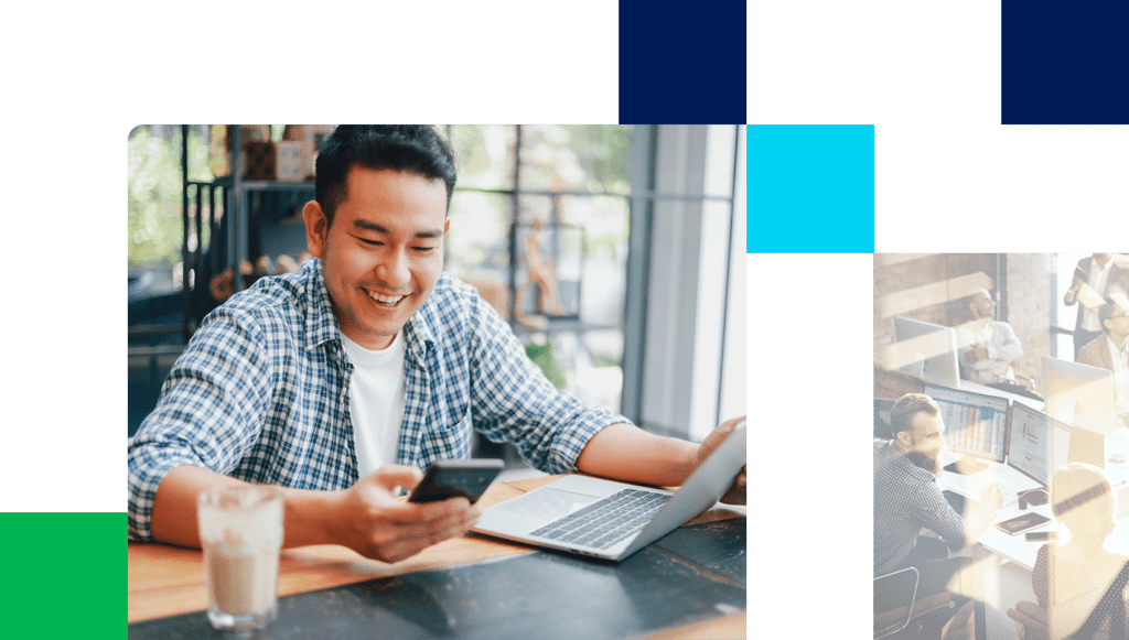Asian young man in blue shirt working with laptop computer and mobile phone