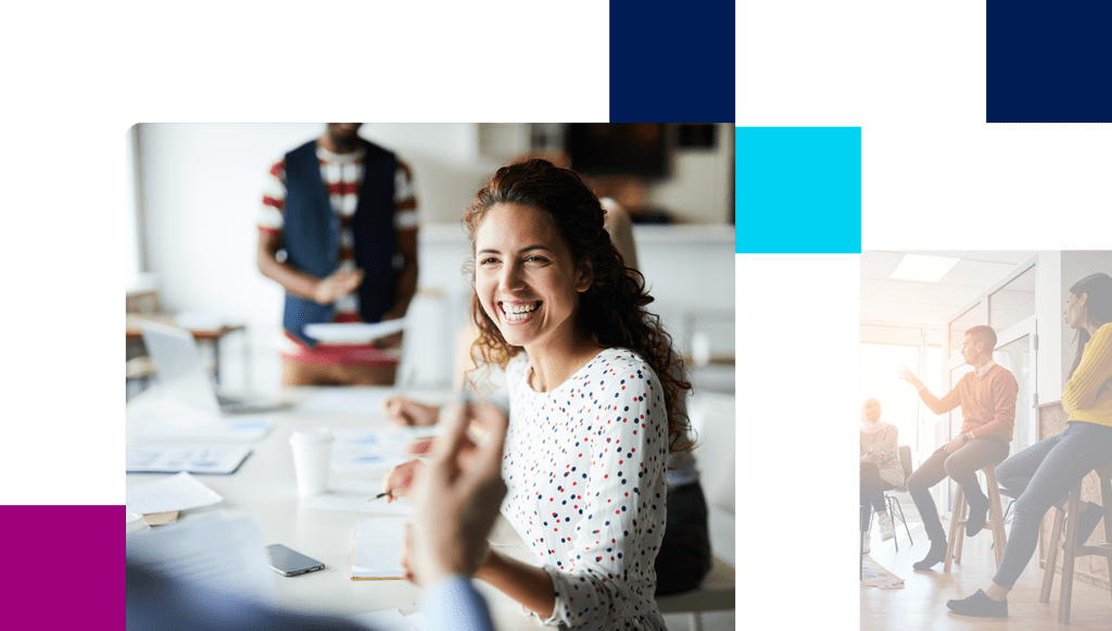 Happy young businesswoman sitting at desk and communicating with her colleagues during a meeting